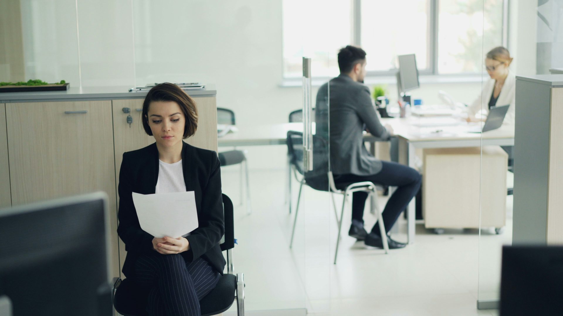 Femme assise dans un bureau tenant des papiers